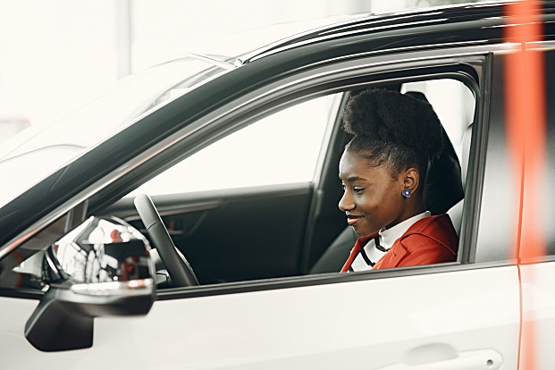 Teenage girl in driver seat of sedan.